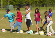 Students dribbling soccer ball