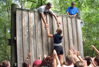 College students scaling wall on ropes course